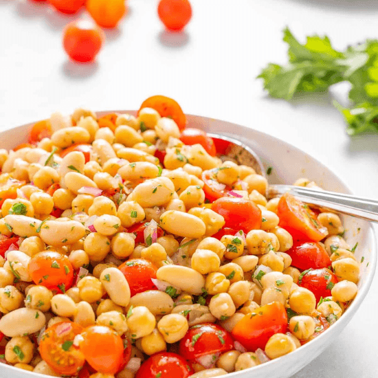 A bright and flavorful farm to table bean salad, featuring tender chickpeas, creamy white beans, and juicy cherry tomatoes tossed with fresh herbs and a light dressing. The vibrant colors and simple, wholesome ingredients highlight the essence of farm to table cooking—fresh, nourishing, and full of natural goodness.