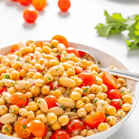 A bright and flavorful farm to table bean salad, featuring tender chickpeas, creamy white beans, and juicy cherry tomatoes tossed with fresh herbs and a light dressing. The vibrant colors and simple, wholesome ingredients highlight the essence of farm to table cooking—fresh, nourishing, and full of natural goodness.