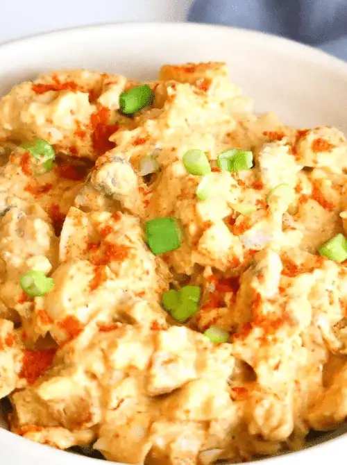Creamy deviled egg salad with a rich, seasoned dressing, garnished with paprika and green onions—perfect for easy Easter finger food ideas and springtime gatherings!