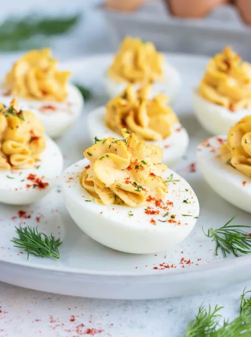 Classic deviled eggs with a creamy, seasoned filling, garnished with fresh dill and paprika—perfect for easy Easter finger food ideas and festive spring gatherings!