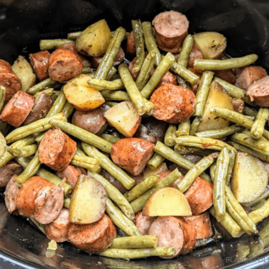 A hearty farm to table slow-cooked meal featuring tender green beans, savory sausage, and golden potatoes, all seasoned to perfection. The rustic combination of fresh, locally sourced ingredients makes this dish a comforting and flavorful classic, perfect for a wholesome, home-cooked meal.