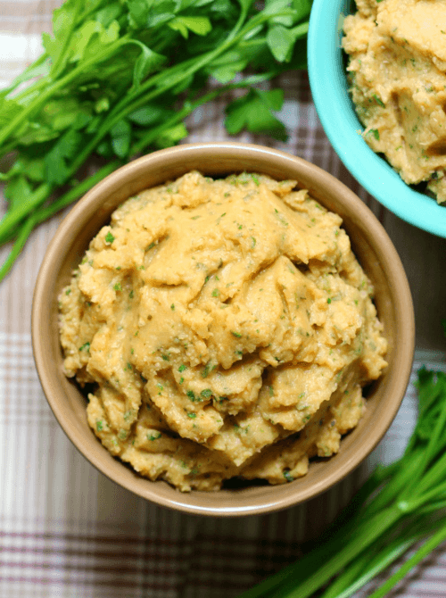 A bowl of creamy homemade hummus garnished with fresh herbs, perfect for easy Easter finger food ideas. A delicious, festive, and healthy appetizer for spring gatherings.