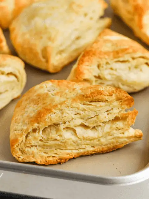 Flaky, golden buttermilk scones fresh from the oven on a baking sheet—simple, buttery layers that make a perfect addition to cozy and classic Mother's Day tea party ideas.
