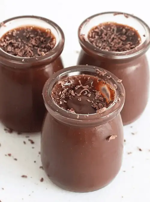 Rich no-bake chocolate pudding served in glass jars and topped with shaved chocolate—an easy 4th of July dessert that’s smooth, indulgent, and naturally egg-free.