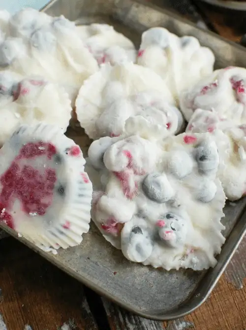 Frozen no-bake yogurt bites with blueberries and raspberries, set in muffin liners—an easy 4th of July dessert that’s healthy, refreshing, and perfect for summer snacking.