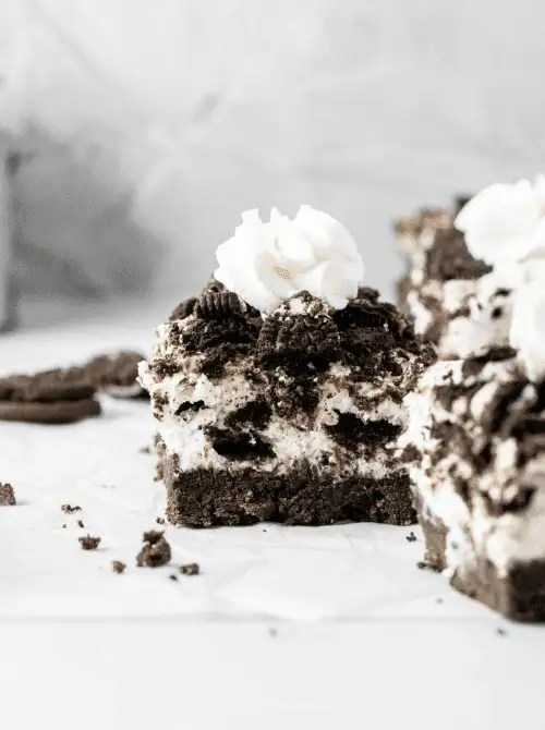 A square of no-bake Oreo cheesecake bar topped with crushed cookies and whipped cream—an easy 4th of July dessert that’s rich, creamy, and full of cookies-and-cream flavor.