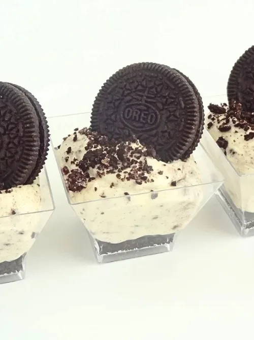 Mini no-bake Oreo cheesecake cups topped with crushed cookies and a whole Oreo—an easy 4th of July dessert served in clear individual portions for parties or picnics.