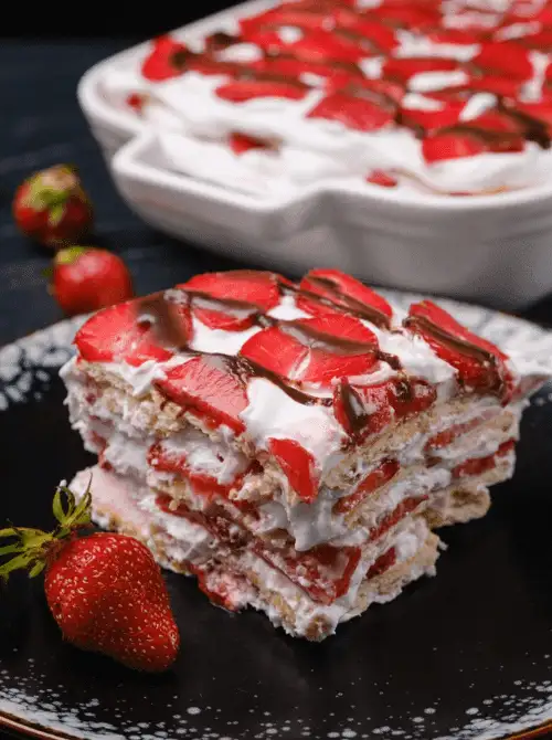 Layered no-bake strawberry icebox cake with whipped cream, graham crackers, and fresh strawberries, drizzled with chocolate—an easy 4th of July dessert that’s cool, creamy, and perfect for summer parties.