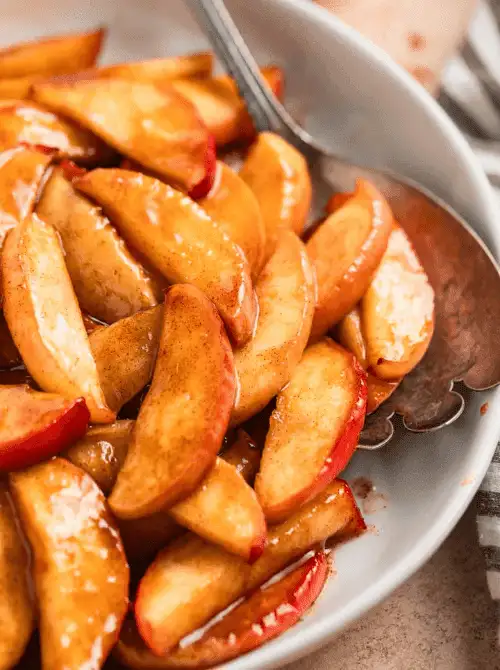 Tender cinnamon-glazed apple slices served warm in a white bowl—sweet, simple, and one of the easiest things to make with apples for cozy fall recipes and quick side dishes.