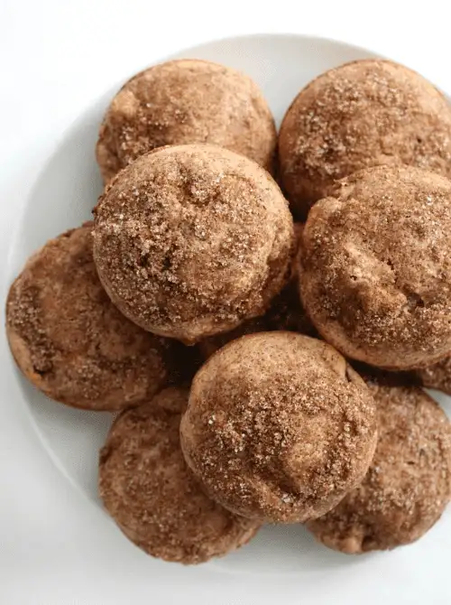 A plate of soft, cinnamon-sugar coated apple muffins—an easy fall bread recipe and a cozy solution for what to make with apples this season.