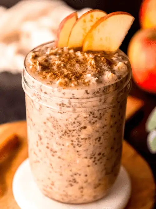 Creamy apple cinnamon overnight oats in a mason jar, topped with sliced apples and a sprinkle of cinnamon—a cozy, prep-ahead option for easy fall recipes and one of the best things to make with apples.