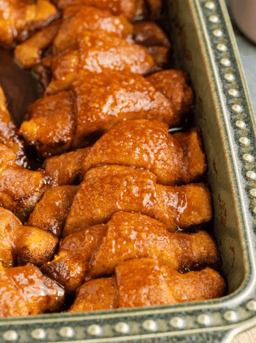 Crescent roll apple dumplings baked in cinnamon sugar syrup, golden and bubbling in a baking dish – a rich, simple fall treat and one of the coziest things to make with apples.