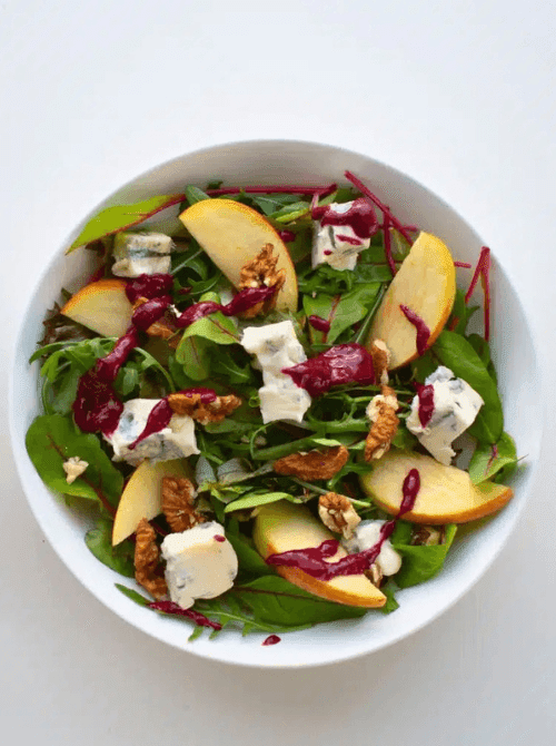 Apple and blue cheese salad with fresh greens, walnuts, and a vibrant berry vinaigrette—bold, tangy, and one of the most creative things to make with apples for easy fall recipes.