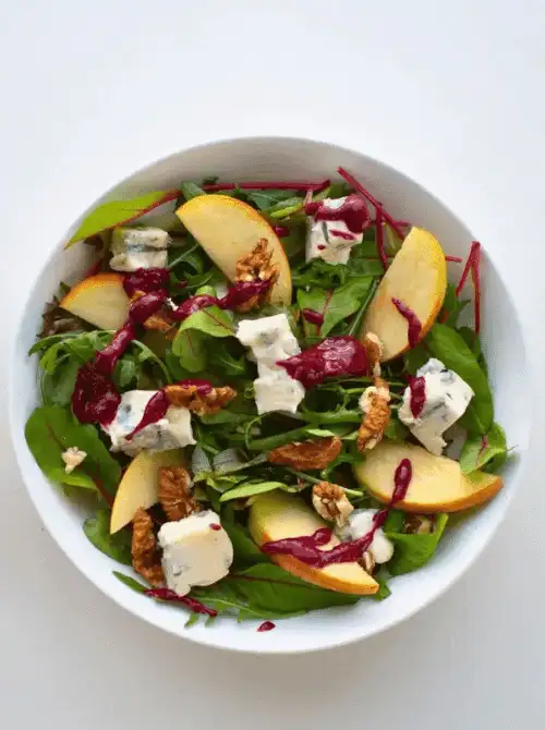Apple and blue cheese salad with fresh greens, walnuts, and a vibrant berry vinaigrette—bold, tangy, and one of the most creative things to make with apples for easy fall recipes.