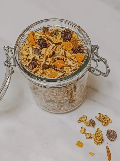 Homemade apple cinnamon granola with dried fruit and seeds in a glass jar—one of the easiest fall recipes and a wholesome option when searching for things to make with apples.