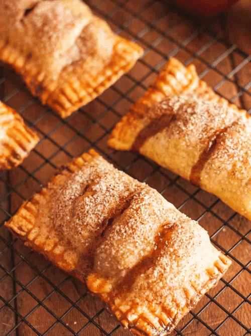 Baked apple hand pies with cinnamon sugar topping cooling on a wire rack – one of the easiest things to make with apples and a perfect simple fall treat.