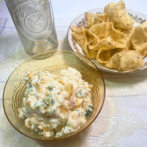 Bowl of creamy Apricot Jalapeño Popper Dip served with a side of corn chips, ready for game day or party snacking.
