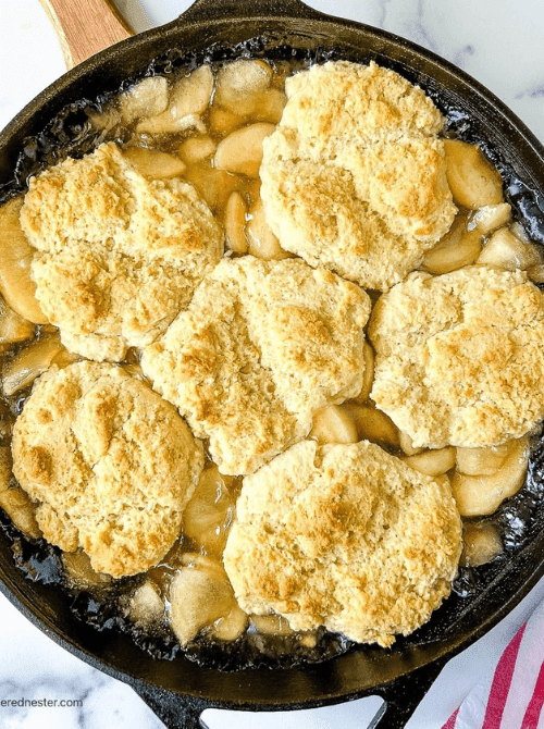 Homemade apple cobbler baked in a cast iron skillet with golden biscuit topping—one of the coziest fall desserts and a classic go-to when searching for things to make with apples.