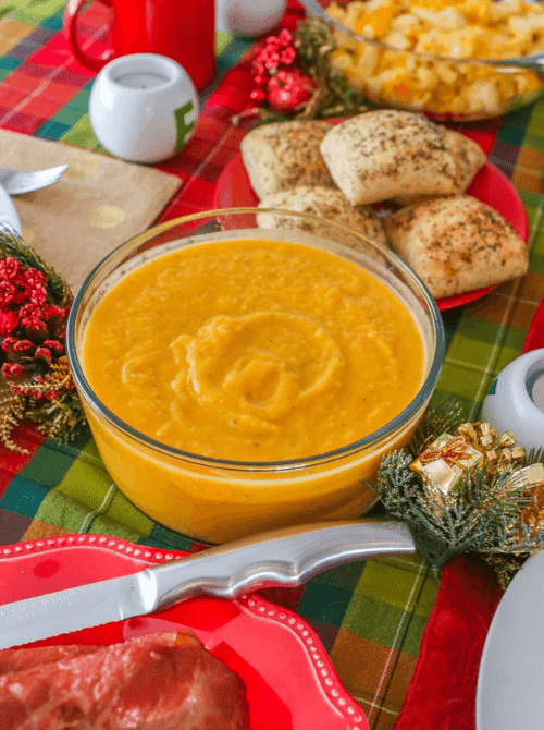 Creamy butternut squash and apple soup served in a glass bowl on a festive fall table—comforting, wholesome, and a cozy choice when looking for easy fall recipes and nourishing things to make with apples.