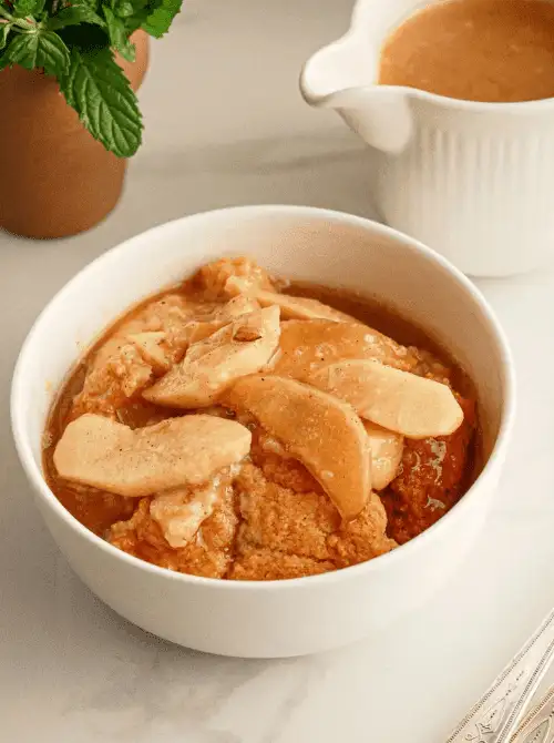 Bowl of warm caramel apple cobbler topped with tender apple slices and sauce—an easy fall dessert and one of the most comforting things to make with apples when the weather turns crisp.
