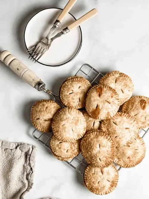 Golden, flaky hand pies filled with apple filling on a cooling rack—one of the coziest things to make with apples and perfect for easy fall desserts.