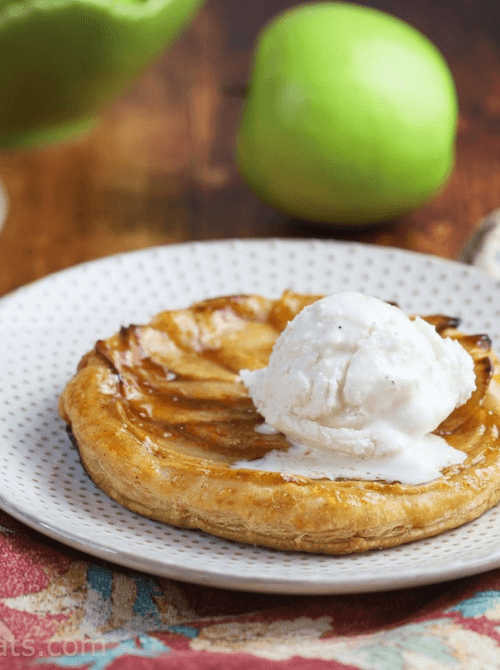 Rustic puff pastry apple tart topped with vanilla ice cream on a dotted plate – one of the easiest things to make with apples and a beautifully simple fall treat.