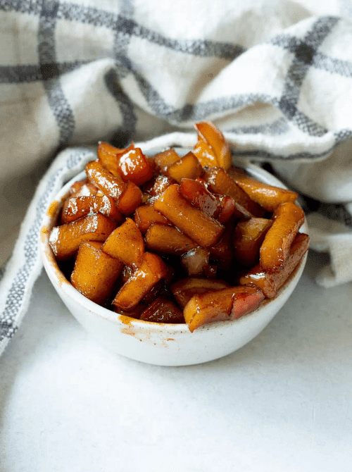 Warm cinnamon-spiced caramelized apples in a small white bowl—sweet, sticky, and one of the coziest things to make with apples for easy fall recipes, perfect as a topping or side.