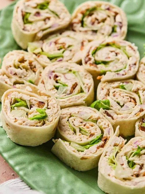 Chicken Caesar pinwheels made with tortillas, lettuce, and red onion—fresh, budget-friendly tailgate food that’s easy to prep ahead and perfect for a crowd.