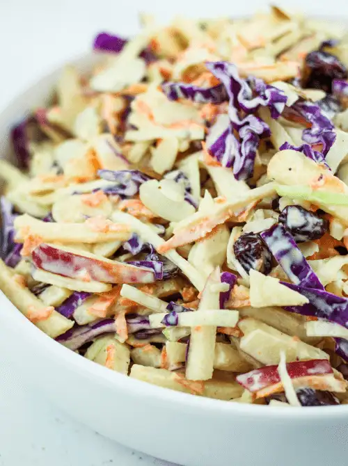 Colorful apple slaw with shredded carrots, red and green cabbage, raisins, and a creamy dressing—crisp, tangy, and a refreshing twist on easy fall recipes and crunchy things to make with apples.