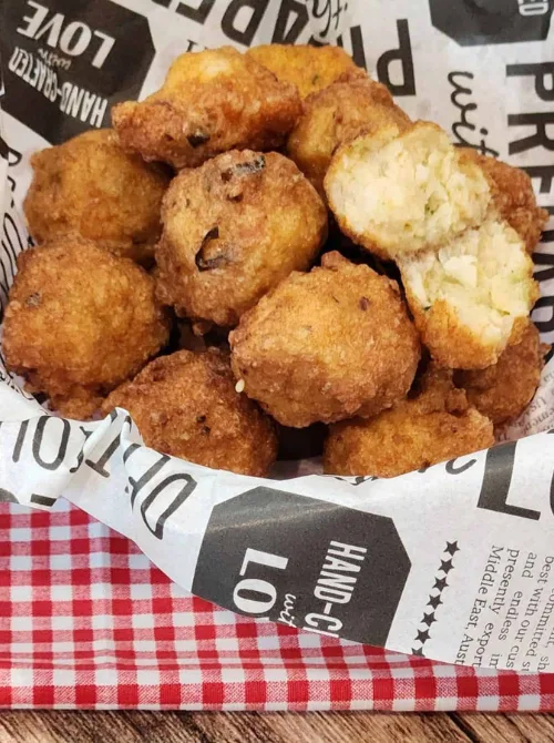 Golden, crispy fried shrimp balls served in a lined basket—an affordable, crowd-pleasing seafood bite perfect for football party snacks on a budget.
