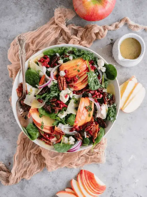 Vibrant fall salad with sliced apples, spinach, pomegranate seeds, pecans, shaved cheese, and red onions—bursting with flavor and color, it’s one of the most beautiful things to make with apples and ideal for easy fall recipes.