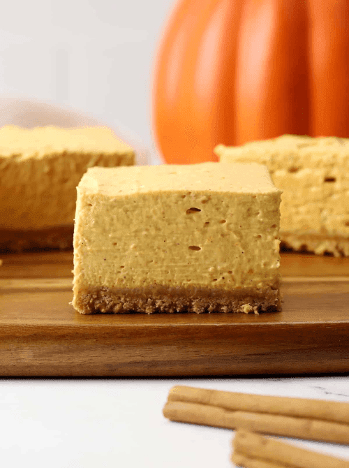 Thick pumpkin cheesecake bars with a graham cracker crust, perfect for fall gatherings — a simple and easy pumpkin cheesecake recipe that’s great for using up leftover pumpkin purée.