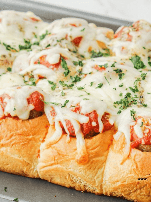 Pull-apart meatball sliders topped with marinara and melted mozzarella on soft rolls—tailgate food on a budget that’s hearty, shareable, and perfect for a crowd.