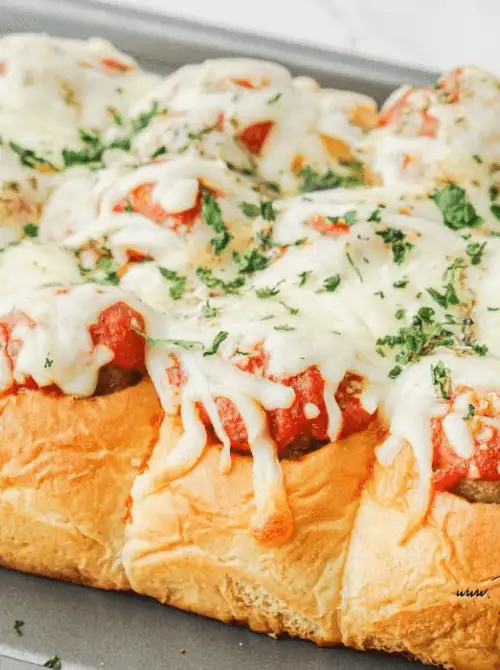 Pull-apart meatball sliders topped with marinara and melted mozzarella on soft rolls—tailgate food on a budget that’s hearty, shareable, and perfect for a crowd.