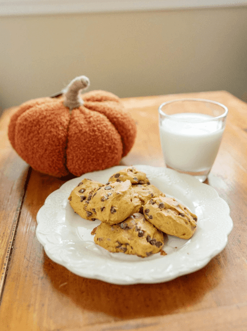 Pumpkin chocolate chip cookies made with leftover pumpkin puree, served with a glass of milk—an easy fall treat for what to make with leftover pumpkin puree.