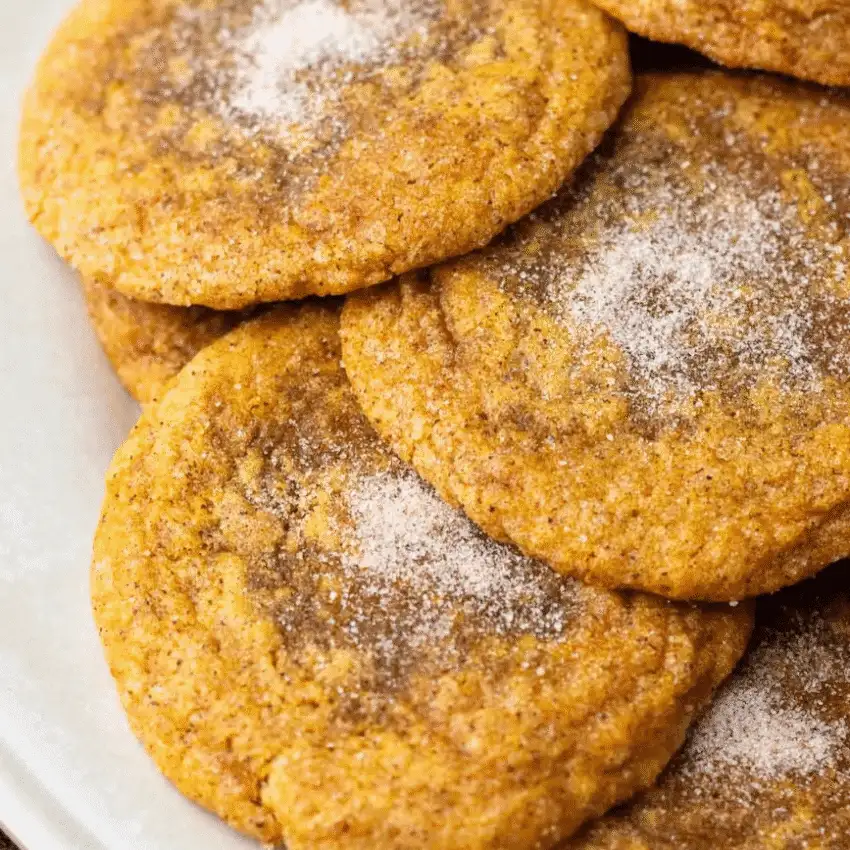 Close-up of soft, sugar-dusted pumpkin cookies stacked on a plate — a delicious answer to what to make with leftover pumpkin puree.