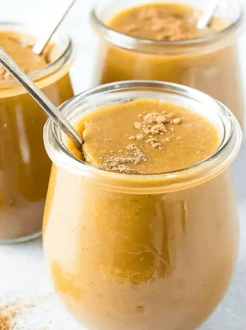 Jars of creamy pumpkin custard topped with cinnamon and served with spoons—an easy, make-ahead pumpkin dessert and a simple way to use up leftover pumpkin puree.