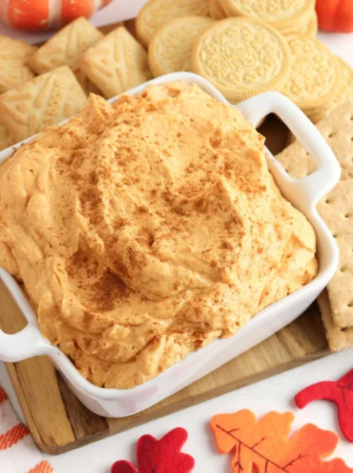Whipped pumpkin dip sprinkled with cinnamon and served with cookies and graham crackers—an easy no-bake pumpkin dessert and fun way to use leftover pumpkin puree for fall gatherings.