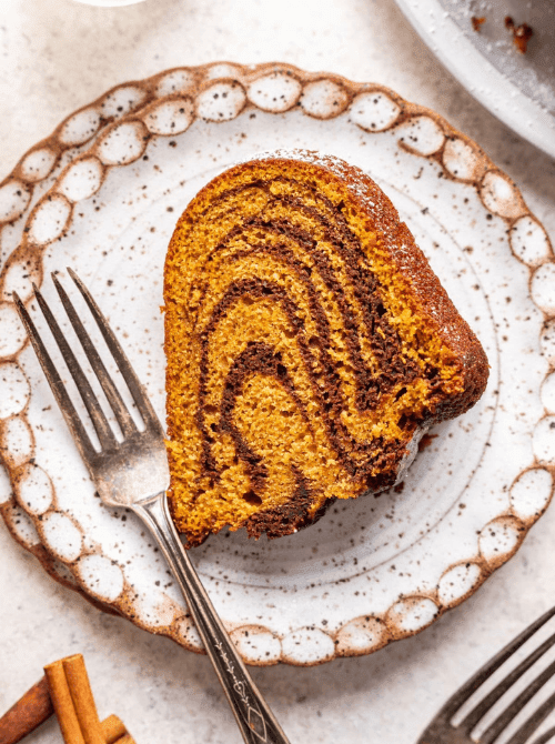 A swirl of chocolate and pumpkin in a slice of bundt cake, beautifully plated with a vintage fork—an eye-catching example of what to make with leftover pumpkin puree for stunning pumpkin cakes and cupcakes.