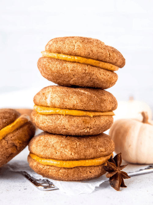 Pumpkin sandwich cookies with creamy filling, made with leftover pumpkin puree—an easy and festive idea for what to make with leftover pumpkin puree.