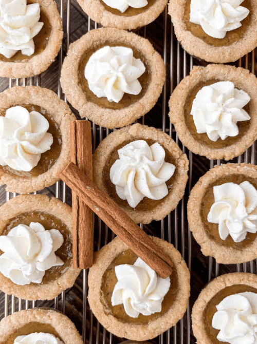 Mini pumpkin pie cookies made with leftover pumpkin puree, topped with whipped cream—an easy dessert idea for what to make with leftover pumpkin puree.