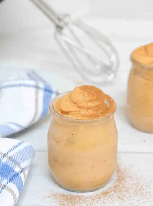 Jar of creamy pumpkin mousse topped with a swirl and dusting of cinnamon—an easy fall pumpkin dessert and delicious way to use leftover pumpkin puree.