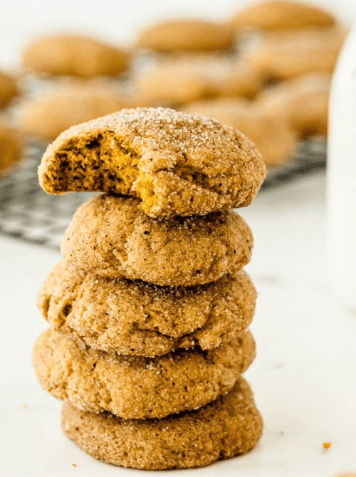 Stack of soft pumpkin spice cookies coated in cinnamon sugar with one bitten, perfect example of what to make with leftover pumpkin puree.