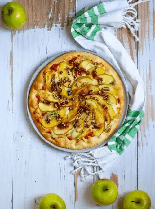 Savory apple and cheese flatbread topped with sliced green apples, pecans, and herbs—an elegant appetizer or light meal that’s both creative and delicious for easy fall recipes and unique things to make with apples.