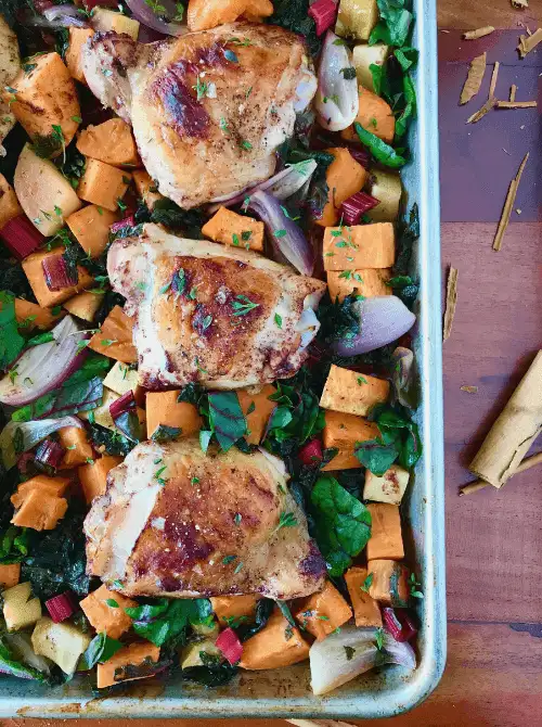 Sheet pan roasted chicken thighs with sweet potatoes, apples, rainbow chard, and red onions—a colorful, one-pan fall meal that’s easy to prep and a satisfying way to use up apples in cozy fall recipes.