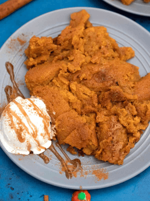 Serving of warm pumpkin dessert topped with a scoop of vanilla ice cream and caramel drizzle on a gray plate—an easy, comforting way to use leftover pumpkin puree in a budget-friendly fall treat.S