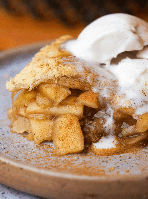 Warm slice of homemade apple pie topped with vanilla ice cream and cinnamon—one of the most classic fall desserts and a delicious way to use up apples when looking for things to make with apples.