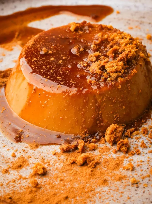 Close-up of vegan pumpkin flan topped with caramel sauce and cookie crumbles—an elegant and creamy pumpkin dessert that’s perfect for using leftover pumpkin puree.