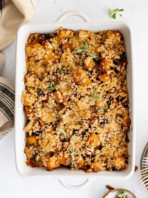 Savory roasted vegetable couscous bake in a white casserole dish—tossed with golden squash, herbs, and breadcrumbs, this Budget-Friendly Thanksgiving Vegetable Side is hearty, rustic, and full of fall flavor.