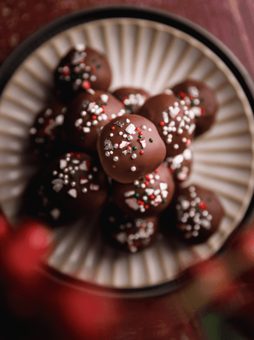Chocolate truffles coated in sprinkles on a festive plate, a homemade DIY Christmas gift and easy edible gift idea for the holidays.